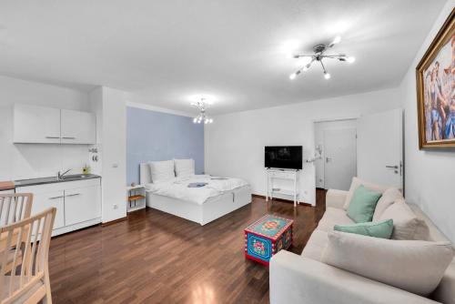 a living room with a white couch and a kitchen at Wohnung im Herzen Münchens nähe Hauptbahnhof in Munich