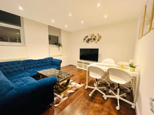 Luxury Morden 4 bedroom Flats which will make you unforgettable في لندن: غرفة معيشة مع أريكة زرقاء وطاولة