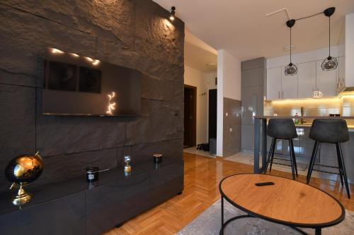 a living room with a stone wall and a table at Apartman Dina in Pirot