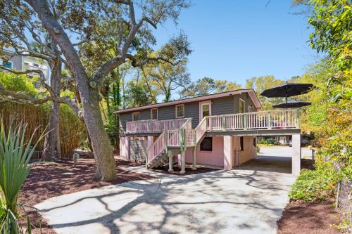 a house with a deck and an umbrella at Folly Vacation Vintage Cottage 317 East in Folly Beach