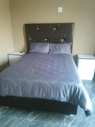 una camera da letto con un grande letto con lenzuola e cuscini bianchi di Zizi's B&B a Tsolo
