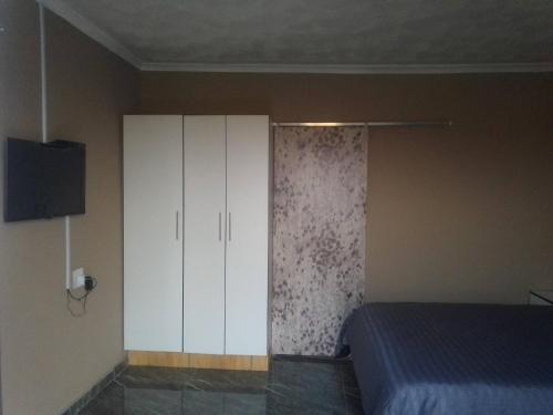 una camera con letto e armadietto bianco di Zizi's B&B a Tsolo