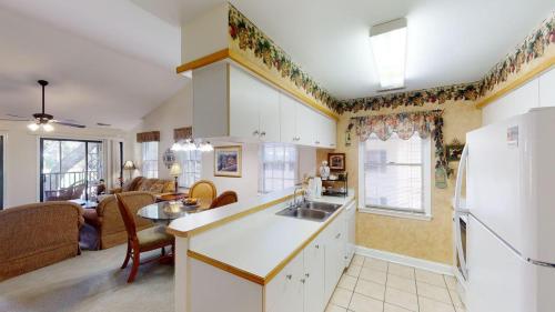 a kitchen and living room with a white refrigerator at Pawleys Plantation Greens 1 Bedroom Retreat in Pawleys Island