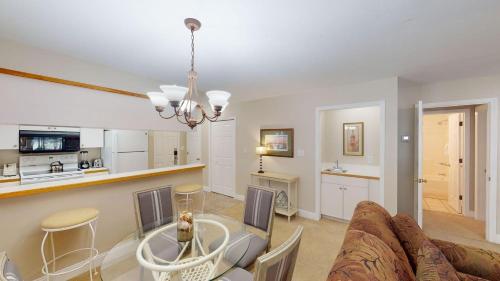 a living room with a couch and a table and a kitchen at 1-BR Golf Suites Views and Amenities in Pawleys Island