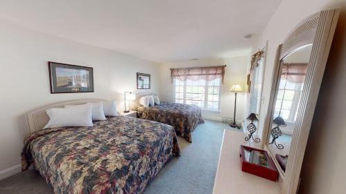 a hotel room with two beds and a mirror at Pawleys Plantation Greens 1BR Retreat in Pawleys Island