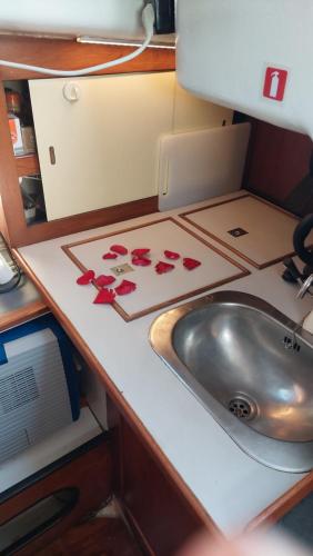 a kitchen counter with a sink and red flowers on it at Vintage Sailboat in Belém in Lisbon
