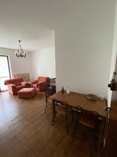 a living room with a table and chairs and a couch at BILOCALE 70Mq giardino cond balconcini vicino OSPEDALI UNIVERSITà in Varese