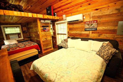 a bedroom with two beds in a log cabin at The Americana - Parker Creek Bend Cabins in Murfreesboro