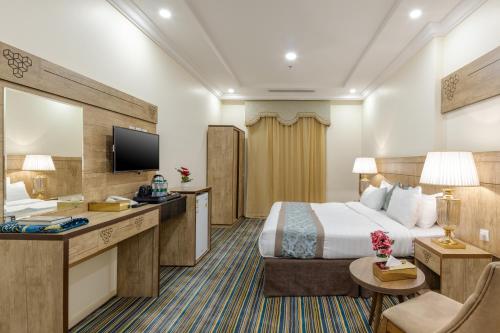 a hotel room with a bed and a television at Snood Al Dana Hotel in Makkah