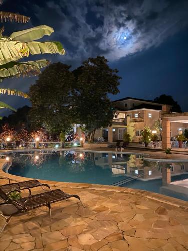 a bench sitting next to a swimming pool at night at Hotel La Ponsa Itatiaia in Itatiaia