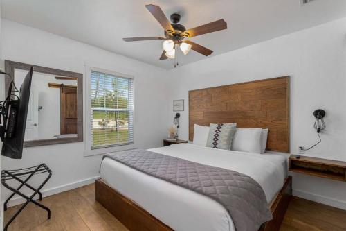 a bedroom with a bed and a ceiling fan at Cozy Cottage • 2 King Beds • Grove • Kayaks • Washer/Dryer in Grove