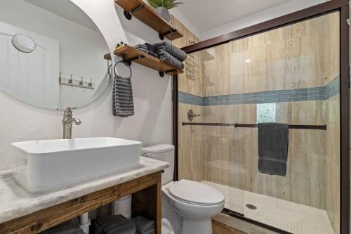 a bathroom with a sink and a toilet and a mirror at Cozy Cottage • 2 King Beds • Grove • Kayaks • Washer/Dryer in Grove