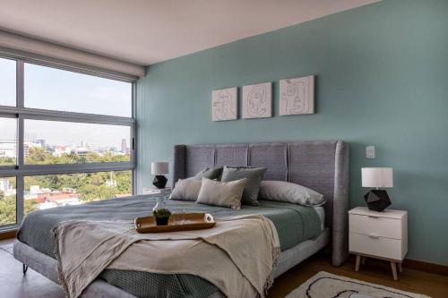 een slaapkamer met een groot bed met blauwe muren bij Departamento en Condesa con Alberca y Gimnasio in Mexico-Stad