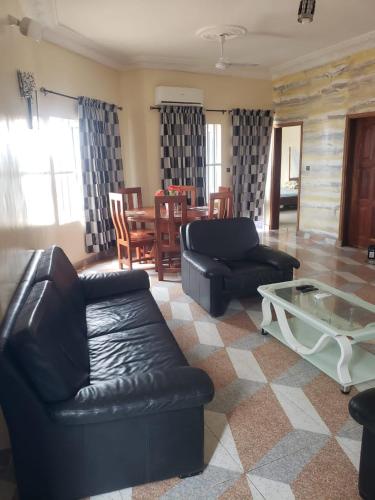 a living room with black leather furniture and a table at Agimdeluxe in Abomey-Calavi