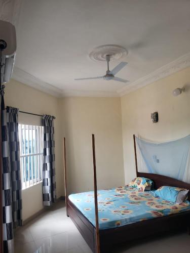 ein Schlafzimmer mit einem Bett mit einer Decke in der Unterkunft Agimdeluxe in Abomey-Calavi