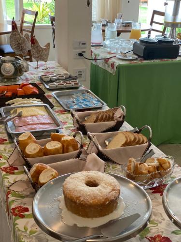 a table filled with different types of pastries and pies at Hotel La Ponsa Itatiaia in Itatiaia