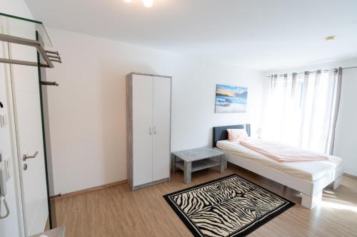 a white room with a bed and a mirror at Ferienparadies Amadeus in Burtenbach