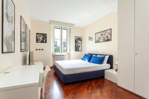 ein Schlafzimmer mit einem Bett mit blauen Kissen in der Unterkunft Bellezza14 - Appartamento Porta Romana / Bocconi in Mailand