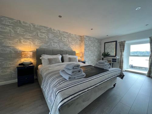 a bedroom with a bed with towels on it at Harbour View on the Lough Edge with Hot Tub in Portaferry