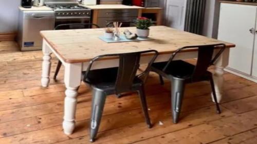 a wooden table with two black chairs and a kitchen at Chalet Platte Solden in Sölden