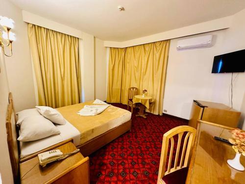 a hotel room with a bed and a desk and a television at Queens Valley Hotel in Luxor