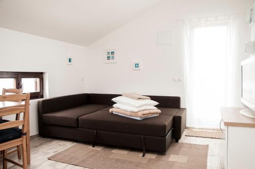 a living room with a brown couch with towels on it at Apartment Ivan in Drvenik Mali