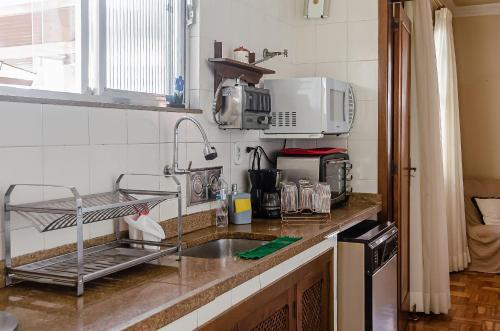 encimera de cocina con fregadero y microondas en Chamosa e aconchegante casa em Petrópolis VGL041, en Petrópolis