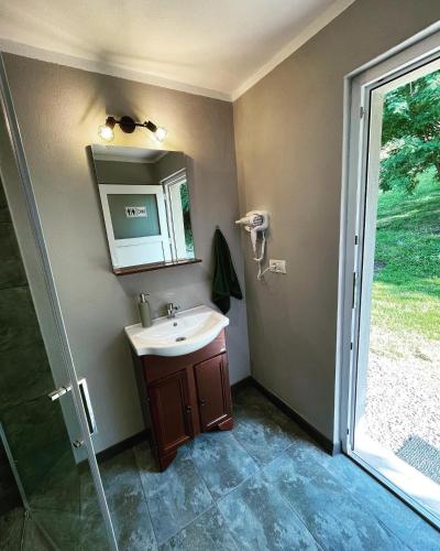a bathroom with a sink and a mirror and a window at WINE ROAD GLAMPING in Cuvin