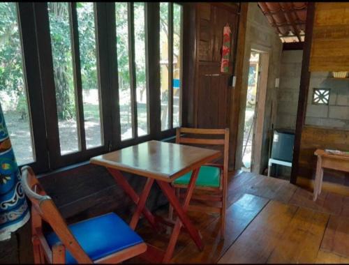 ein Esszimmer mit einem Tisch und Stühlen in einer Hütte in der Unterkunft Chalé com privacidade em Imbassai in Mata de Sao Joao