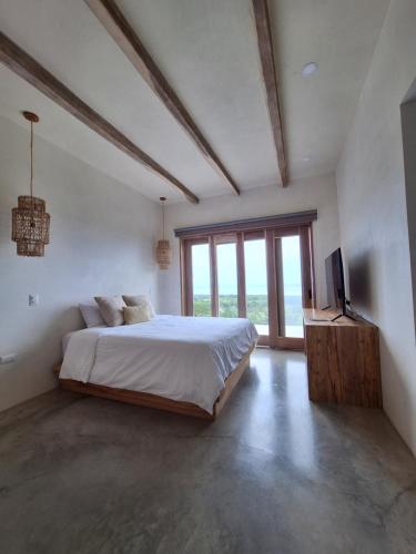a bedroom with a bed and a television in it at Casa Jacito in Ayampe
