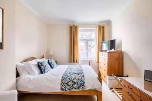 a bedroom with a bed and a dresser and a television at Room with Private Bath in Pontcanna in Cardiff