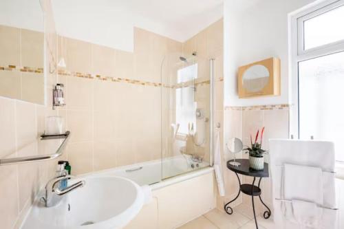 a white bathroom with a sink and a bath tub at Room with Private Bath in Pontcanna in Cardiff