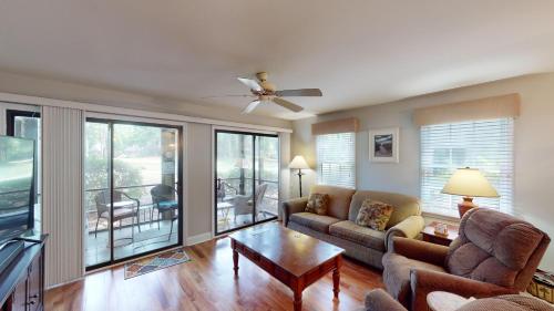 a living room with a couch and a ceiling fan at Scenic Golf Course Suites Modern 1BR with Balcony in Pawleys Island