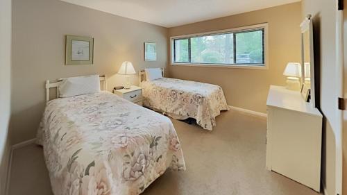 a bedroom with two beds and a window at Scenic Golf Villa River Club 2BR Getaway in Pawleys Island