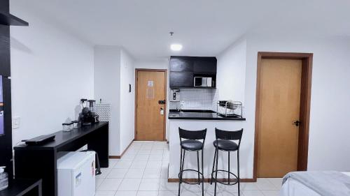 uma cozinha com dois bancos de bar num quarto em Flat em Aguas Claras - Brasília - MADB1005 em Águas Claras
