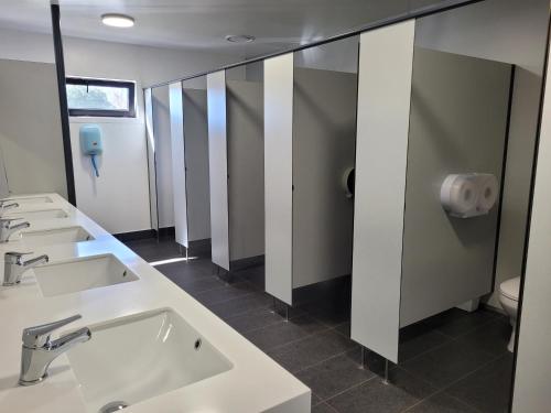 La salle de bains est pourvue de lavabos, de miroirs et de toilettes. dans l'établissement Hampshire Holiday Parks - Wanaka, à Wanaka