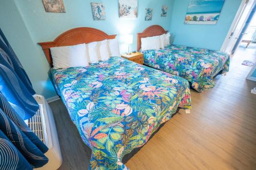 a bedroom with two beds with colorful sheets at Stunning View, Direct Oceanfront, Boardwalk, Pools in Myrtle Beach