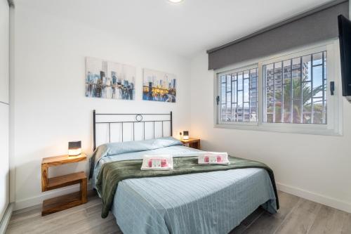 un dormitorio con una cama y una ventana en Las Rosas Sunset Apartment, en Arona