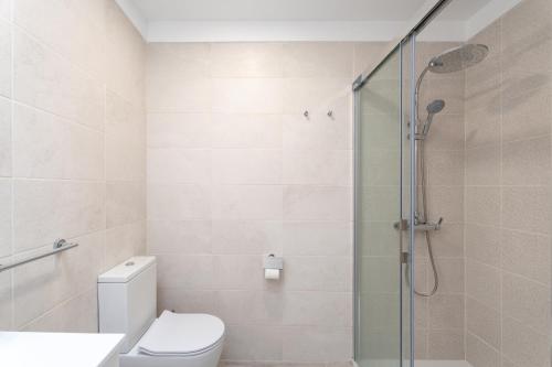 Un baño con inodoro y ducha de cristal. en Las Rosas Sunset Apartment, en Arona