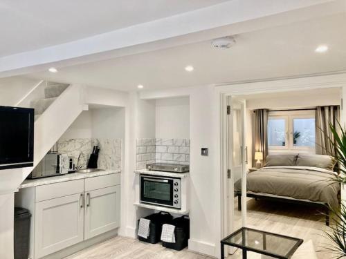 a bedroom with a bed and a kitchen with a sink at Brighton Palms 2 in Brighton & Hove
