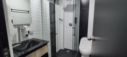 a bathroom with a toilet and a sink and a shower at Hostel Boutique Nido de Loros in Medellín