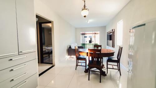 a kitchen and dining room with a table and chairs at CASA NA RUA DO PIRUÍ EM AREMBEPE com ar in Arembepe