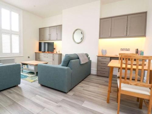 a living room with a blue couch and a table at The Hideaway - Perfect couples retreat with Free parking on driveway in Lytham St Annes