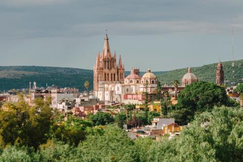 a view of a city with a cathedral in the background at Agua Santa Hotel Boutique in San Miguel de Allende