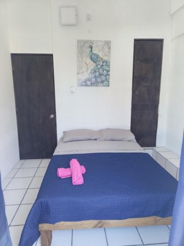 a bed with a pair of pink shoes on it at Azul y buenas noches in Orizaba