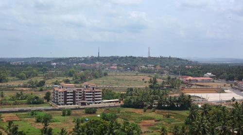 a building in the middle of a field with trees at Athome Comforts Panjim Donapaula in Panaji