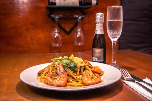 a plate of shrimp pasta next to a glass of wine at Chill Out Hostel in Boracay