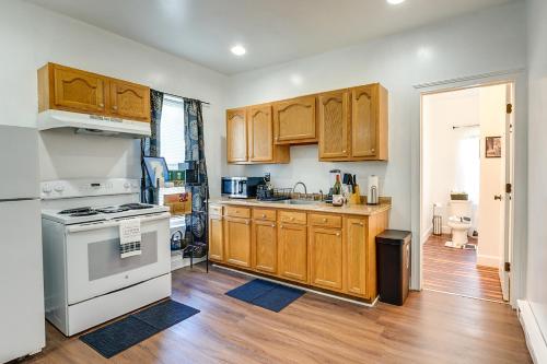 a kitchen with wooden cabinets and a white stove top oven at Allentown Vacation Rental - Walk Downtown! in Allentown