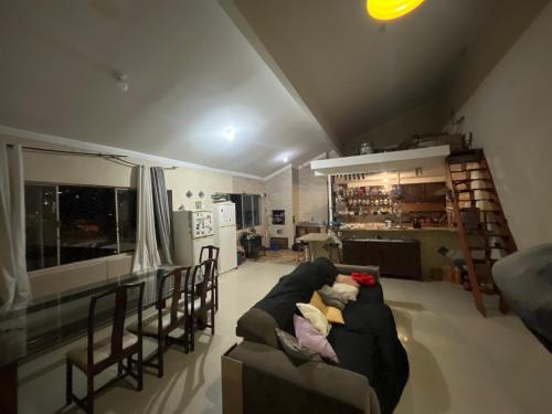 a living room with a couch and chairs and a kitchen at Quarto Hostel Curitiba in Curitiba