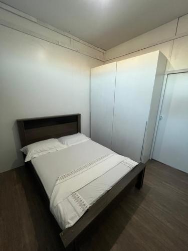 a bedroom with a large bed with white sheets at Quarto Hostel Curitiba in Curitiba